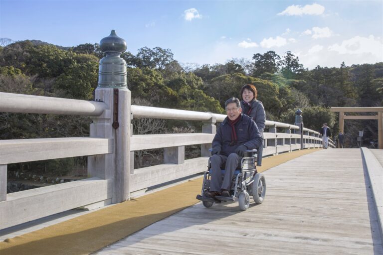 内宮を参拝する車いすの男性とサポートする女性